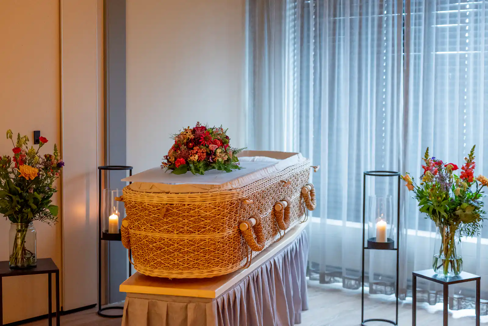 Rieten uitvaartmand met bloemen in een opbaarkamer